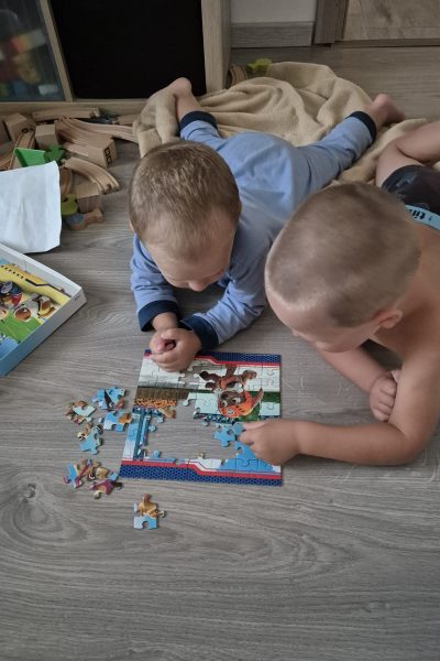 Két kisfiú puzzle-t rak össze a szőnyegen