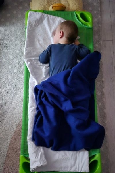 Kisgyerek derékaljon és pokróccal a bölcsődei alváshoz
