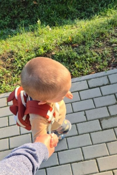 Kisgyerek kézen fogva érkezik a bölcsődébe